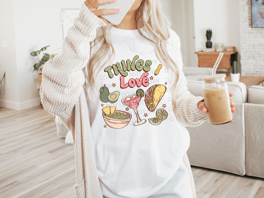 a woman is holding a drink and wearing a t - shirt