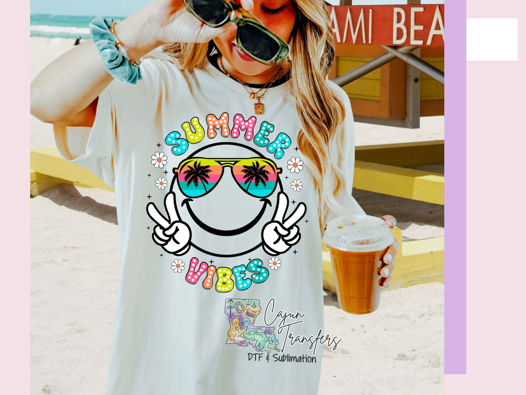 a woman wearing sunglasses and a t - shirt on the beach