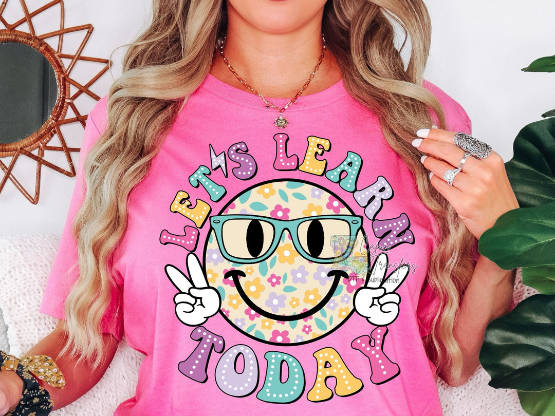 a woman wearing a pink shirt with a smiley face