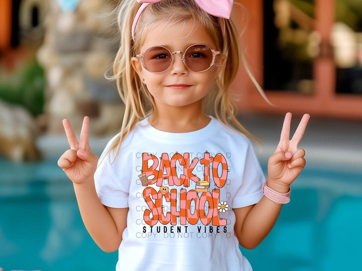 a little girl wearing a shirt that says back to school