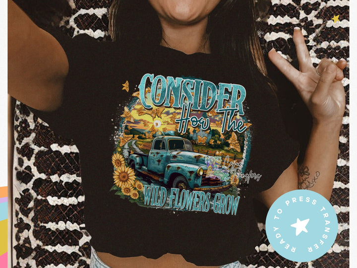 a woman wearing a black shirt with a blue truck on it