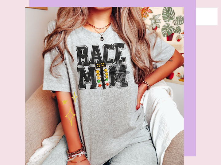 a woman sitting on a couch wearing a race mom shirt