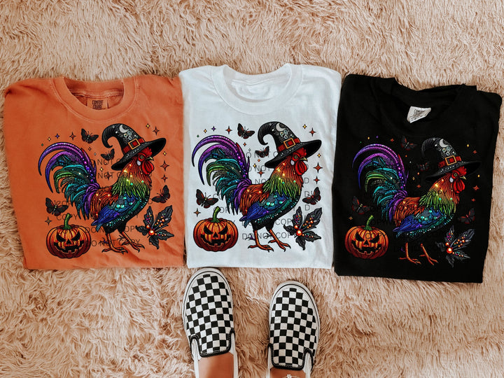 three t - shirts with colorful roosters and pumpkins on them