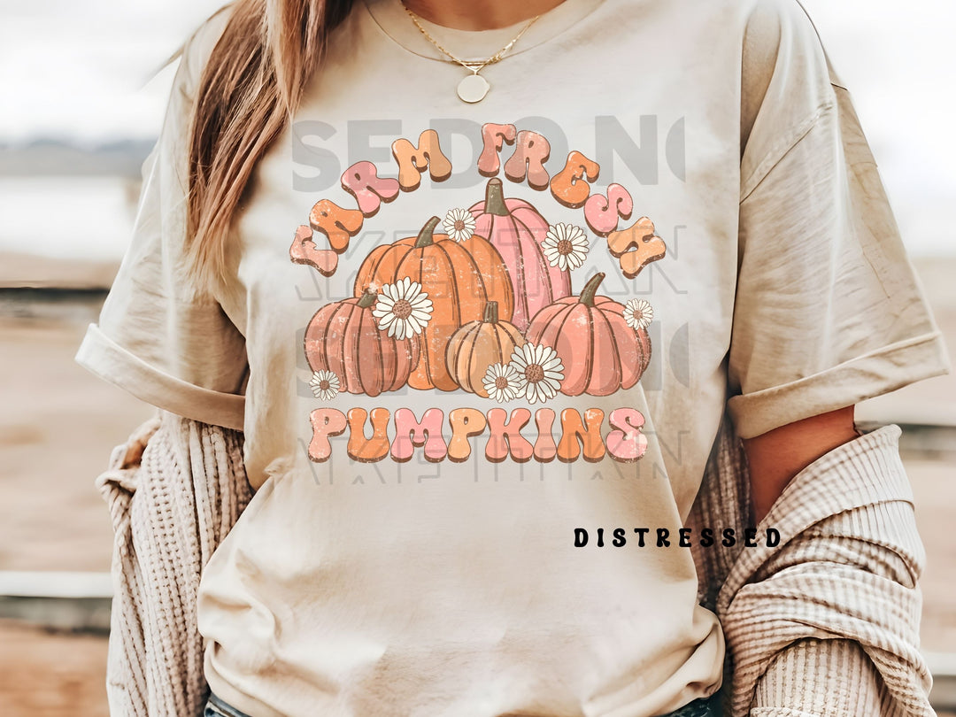 a woman wearing a white shirt with pumpkins on it