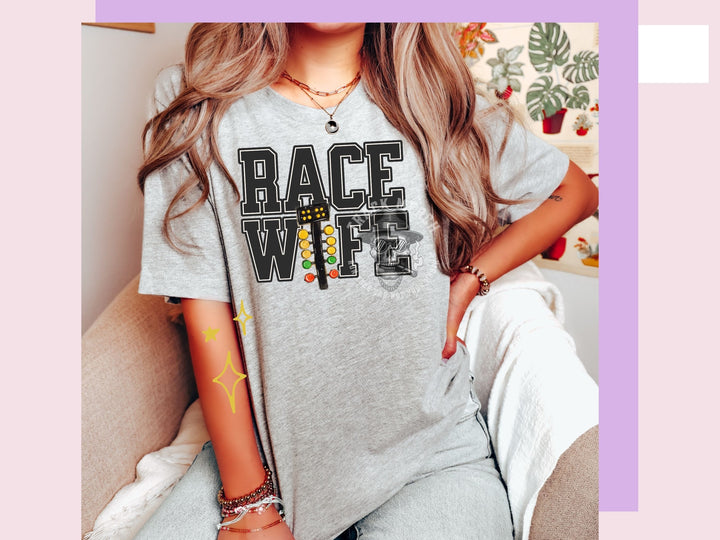 a woman sitting on a couch wearing a race wife shirt