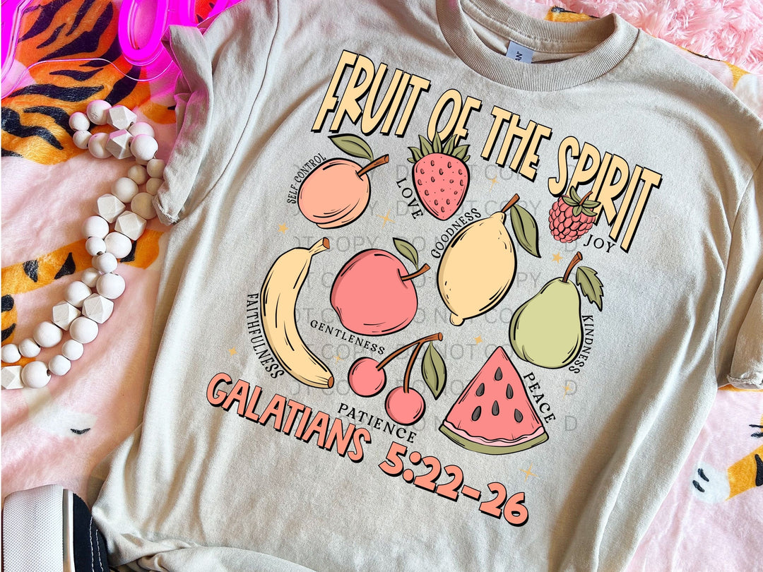 a fruit of the spirit t - shirt sitting on a bed