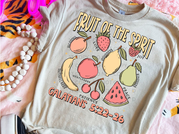 a fruit of the spirit t - shirt sitting on a bed