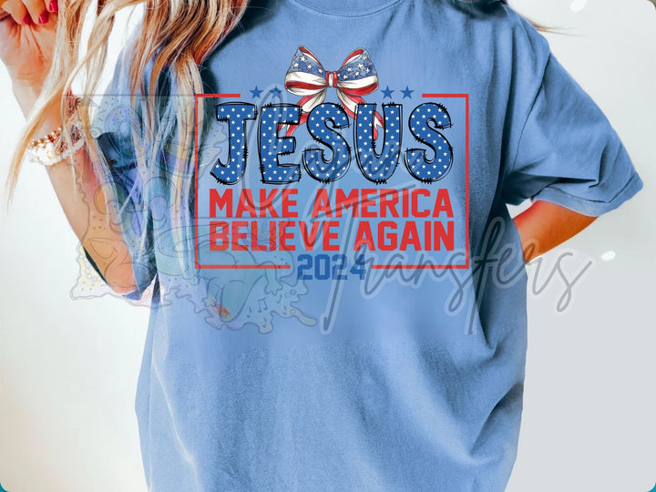 a woman wearing a blue t - shirt that says jesus make america believe again