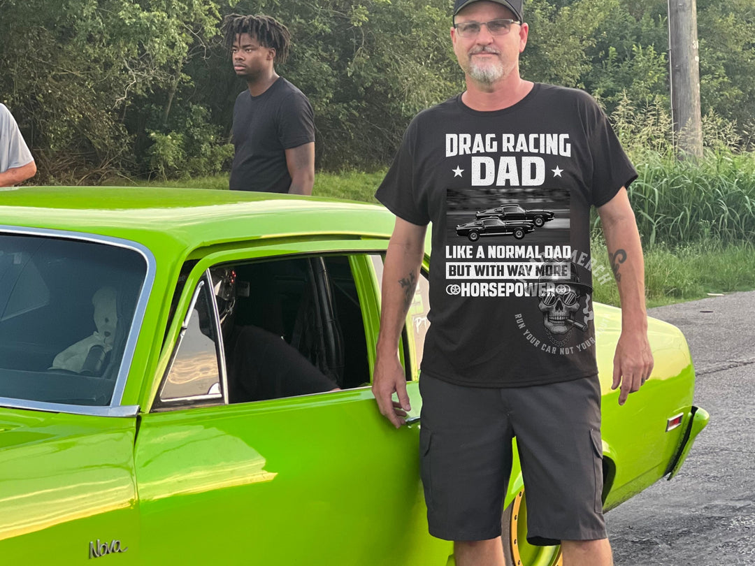 a man standing next to a green car