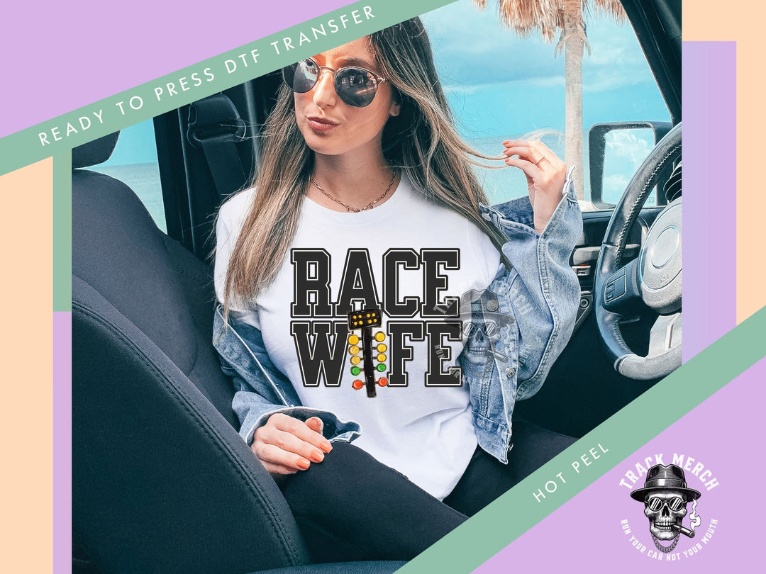 a woman sitting in a car wearing a race wife t - shirt