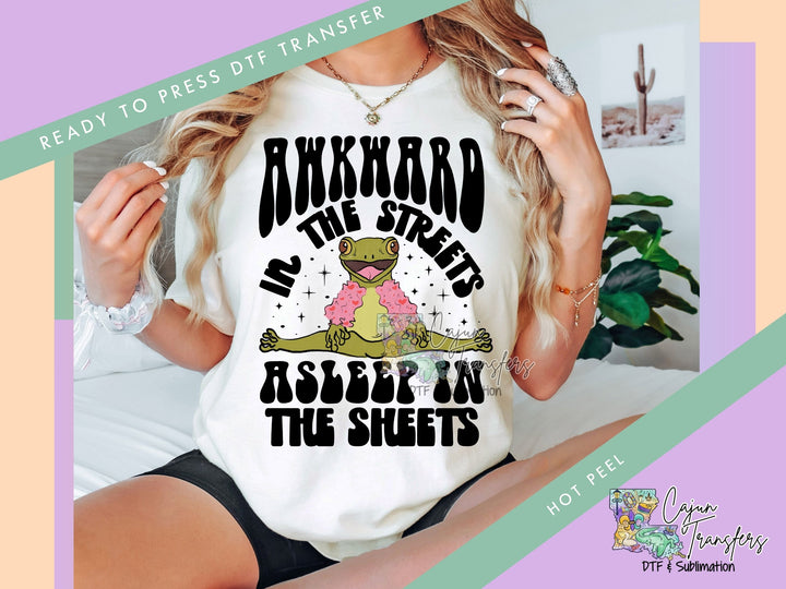 a woman wearing a t - shirt that says awkward in the streets asleep in the