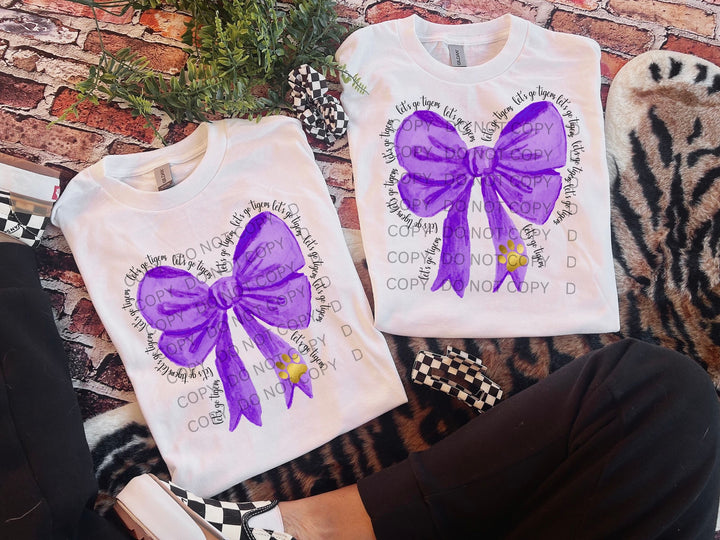 a pair of purple bows on a white shirt