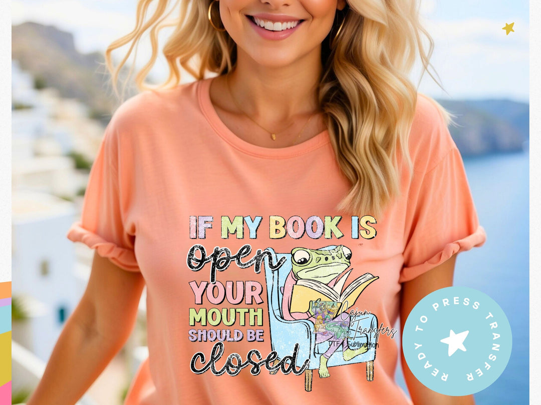 a woman wearing a t - shirt that says if my book is open your mouth