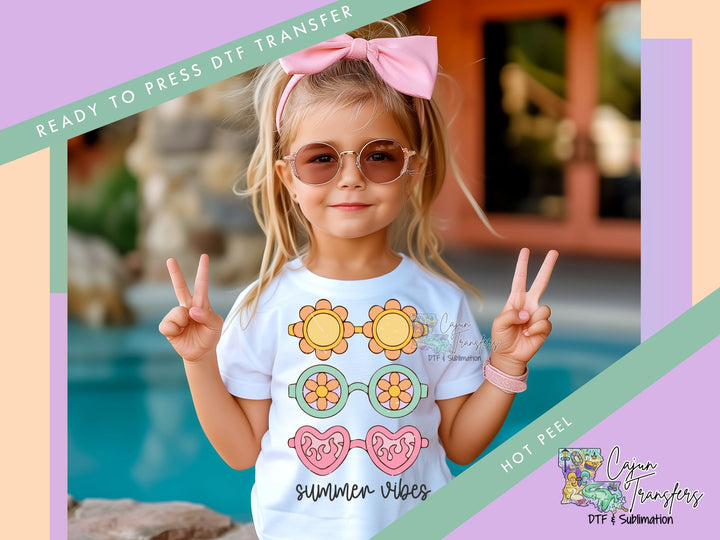 a little girl wearing glasses and a pink bow holding up two peace signs