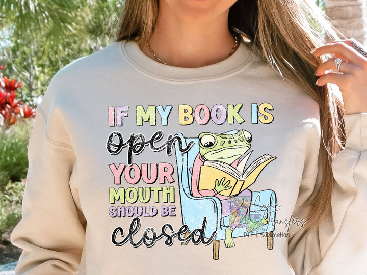 a woman wearing a sweatshirt that says if my books open your mouth should be closed