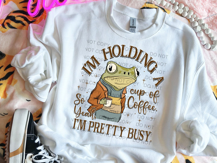 a t - shirt that says i'm holding a cup of coffee and i