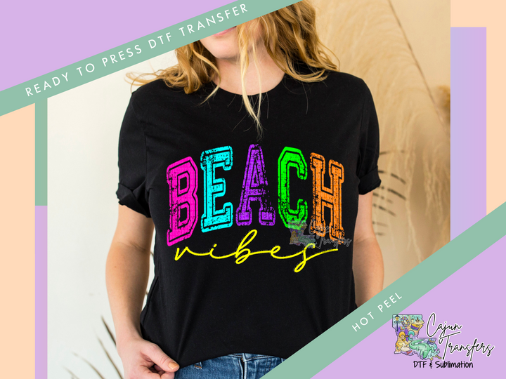 a woman wearing a t - shirt with the words beach written in multicolored