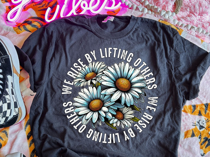 a black t - shirt with white daisies on it
