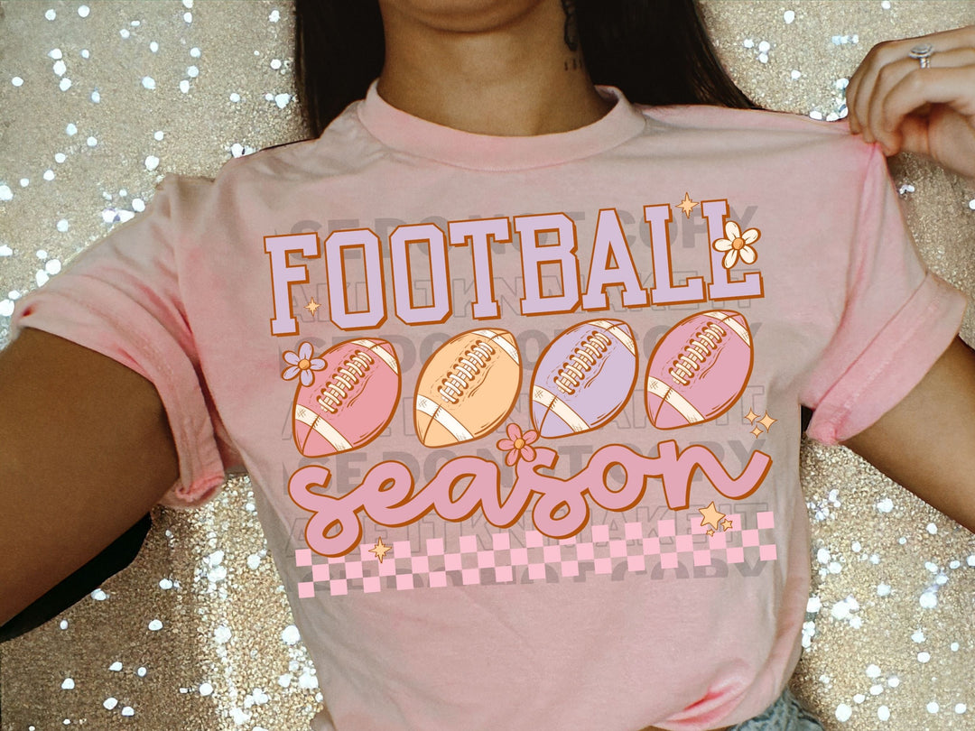 a woman wearing a pink football season shirt