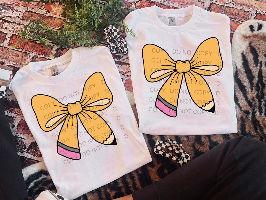 a pair of t - shirts with a yellow bow on them
