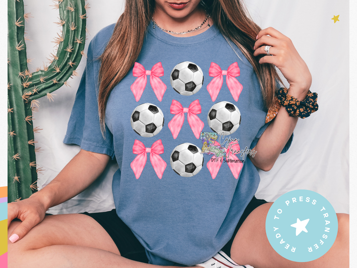 a woman wearing a t - shirt with soccer balls on it
