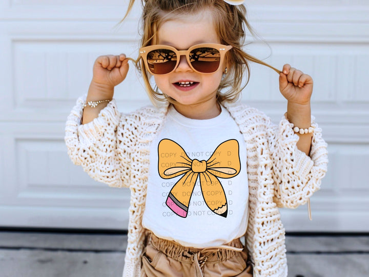 a little girl wearing sunglasses and a bow t - shirt
