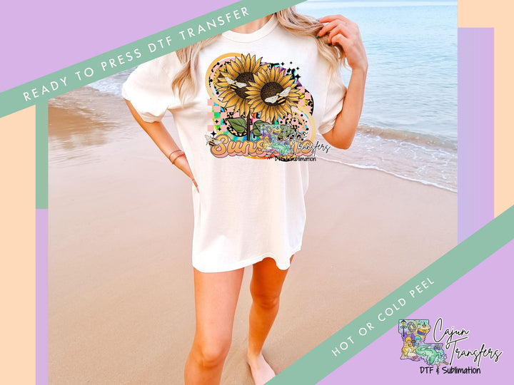 a woman standing on a beach holding a t - shirt