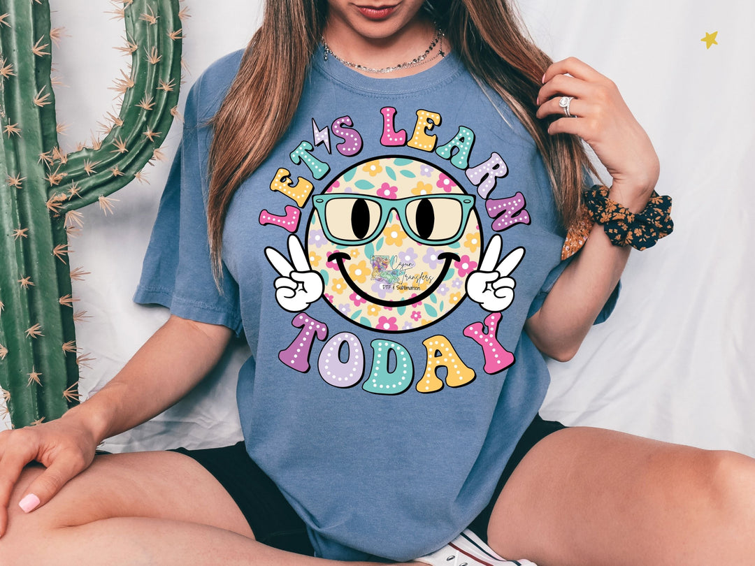 a woman sitting on a bed wearing a t - shirt that says it's